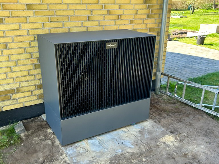 En varmepumpe, der står uden for et hus.
